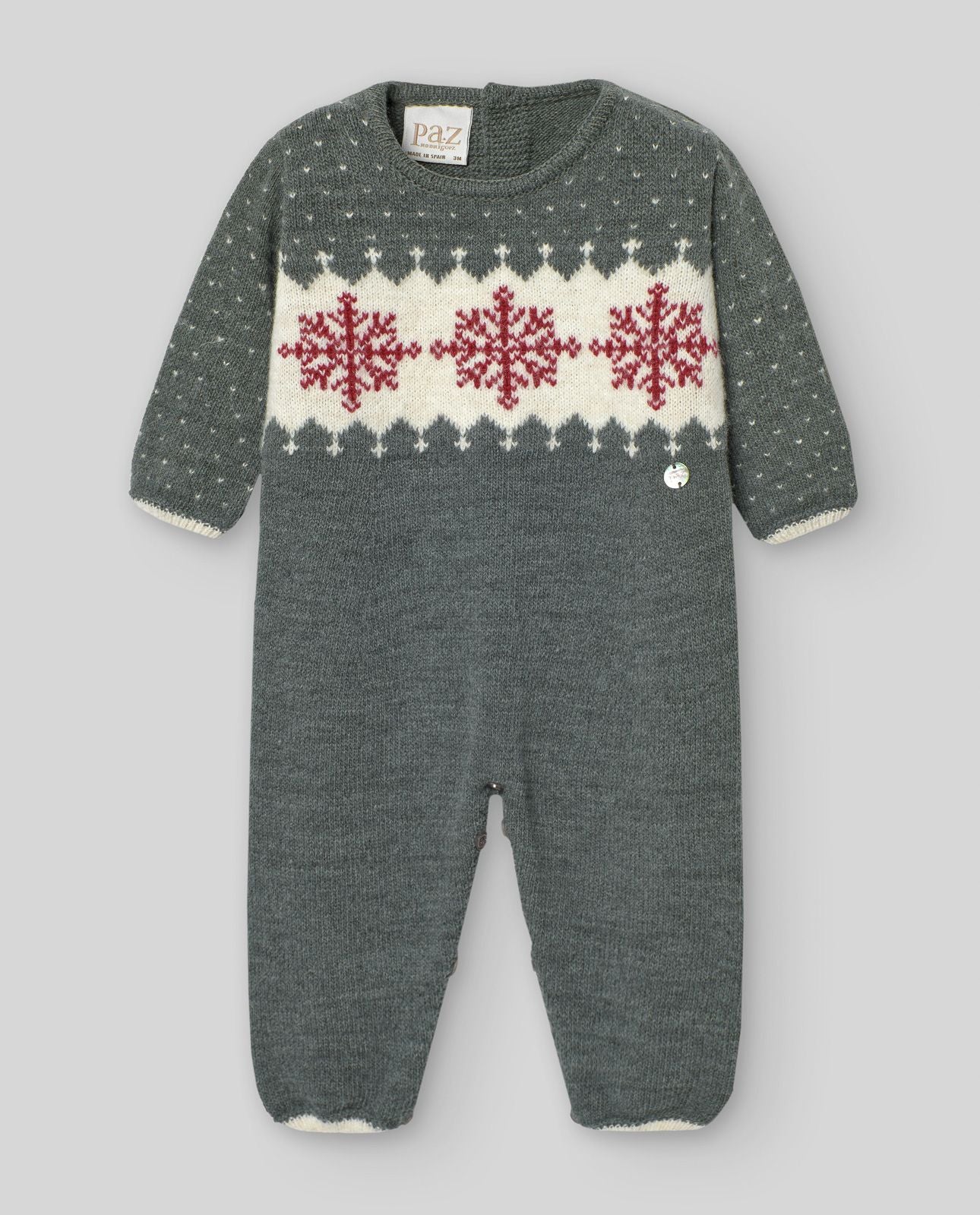 A baby is wearing a sweater with snowflakes on it.;A baby is wearing a grey and white knitted onesie.