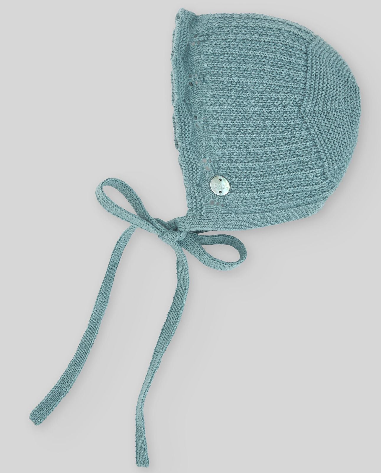 A blue knitted hat with a white button on it;A blue knitted hat with a white button on it