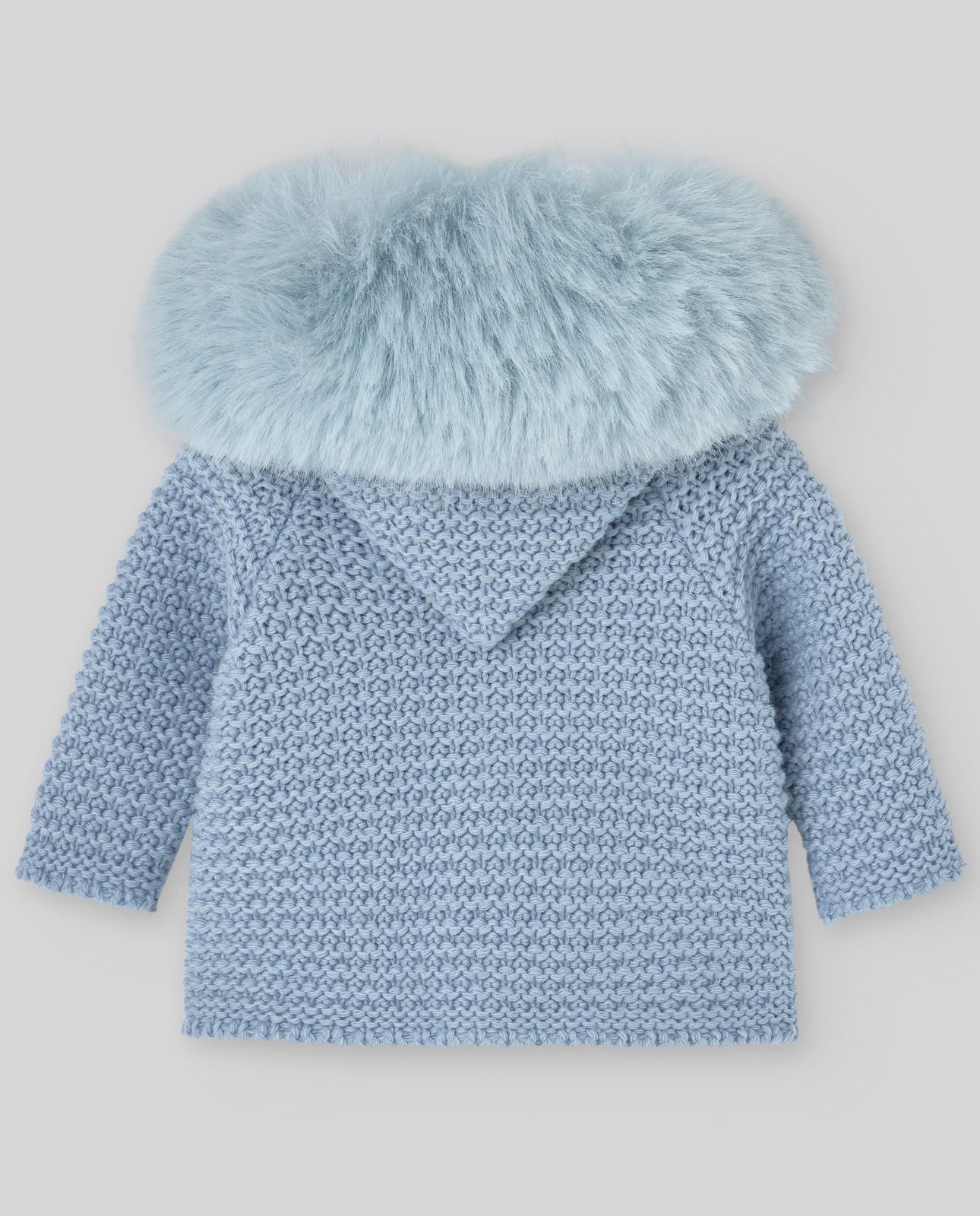 A baby is wearing a blue sweater with a fur collar.;A baby is wearing a blue sweater with a fur hood.;A baby is wearing a pink sweater with a fur collar;A baby is sitting on a bed wearing a hat and a jacket.