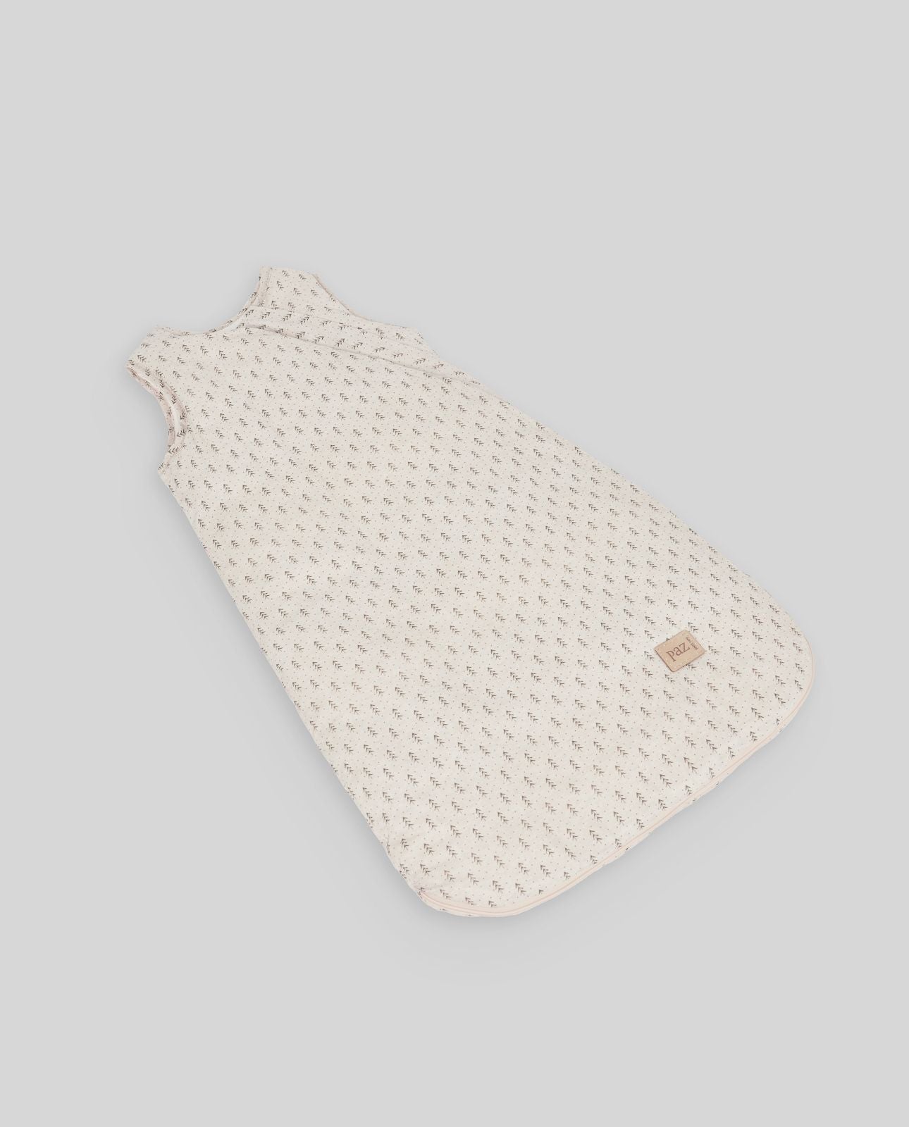 A baby sleeping bag with polka dots on it is sitting on a table.