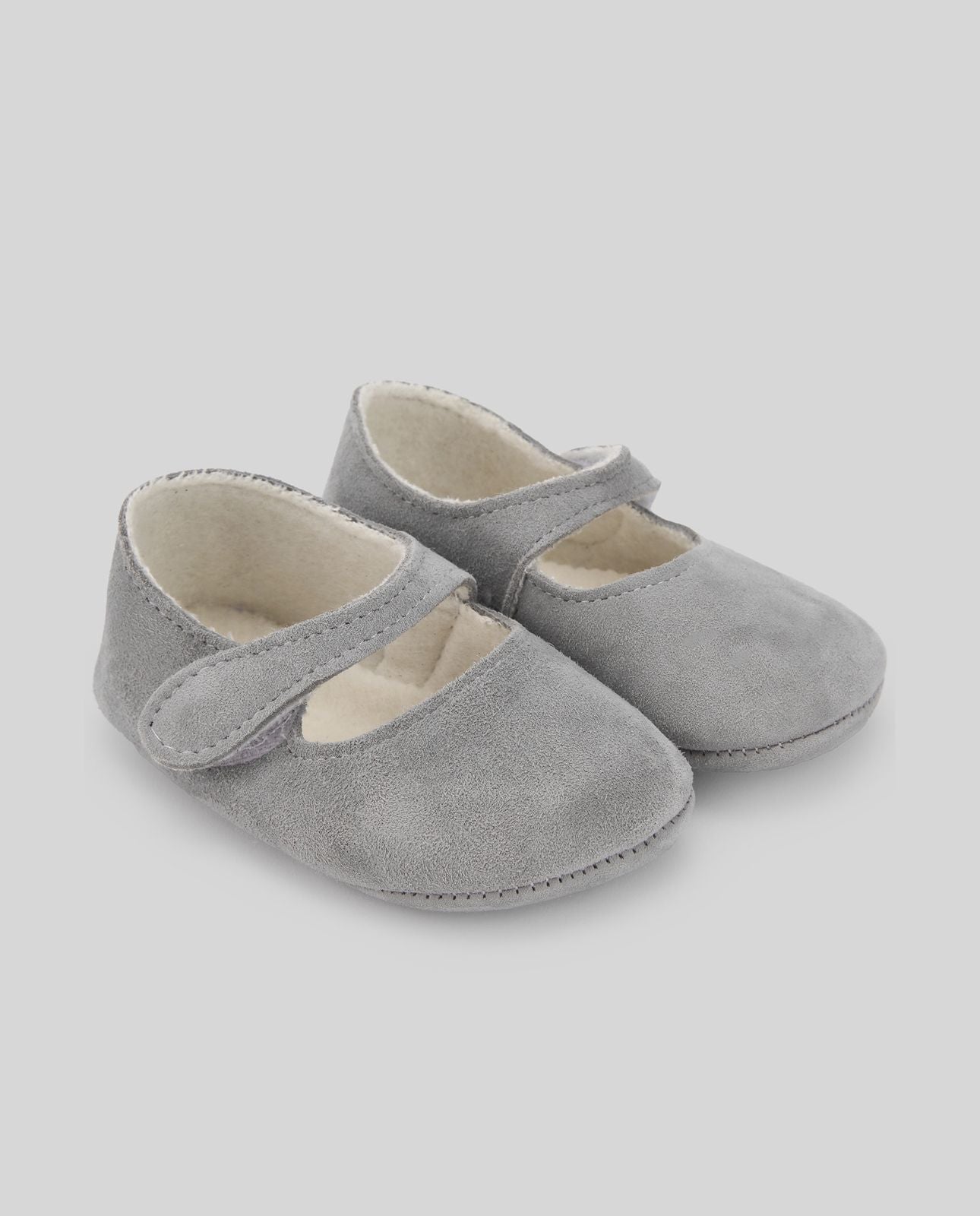 A pair of grey baby shoes on a white background.