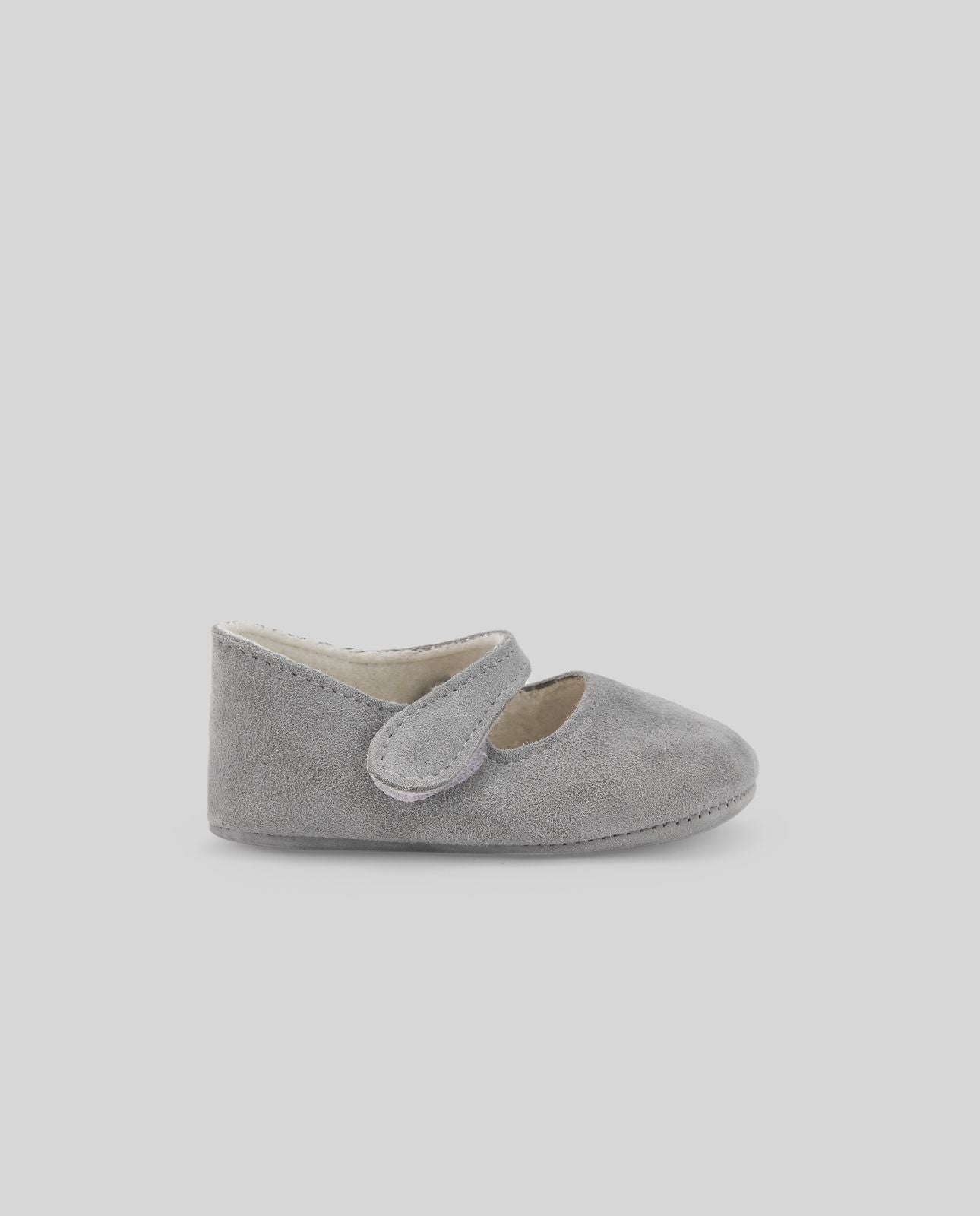 A pair of grey baby shoes on a white background.;A pair of baby shoes with a strap on a white background.;A pair of white baby shoes on a white background.;A pair of pink baby shoes on a grey background;A pair of beige baby shoes on a white background
