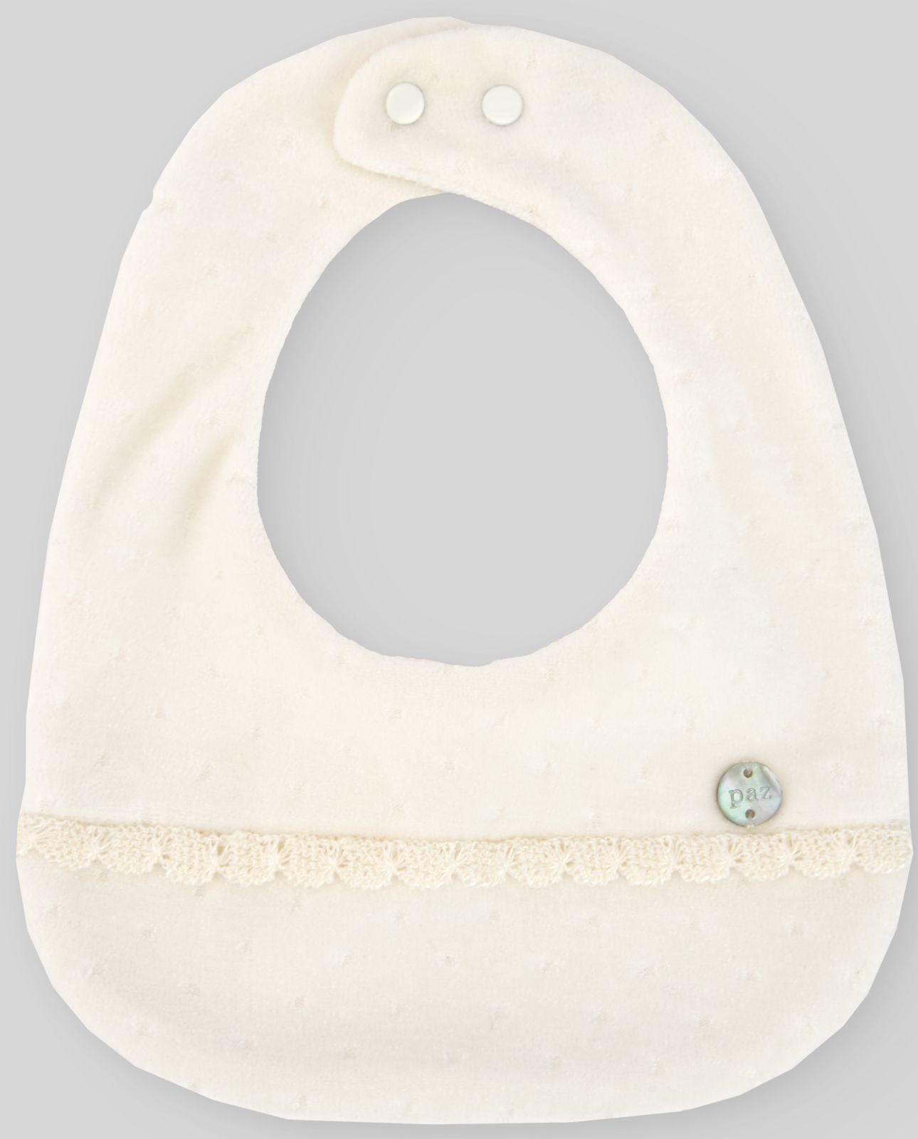 A white bib with a lace trim and a button on it is on a white surface.;A white baby bib with a button on it