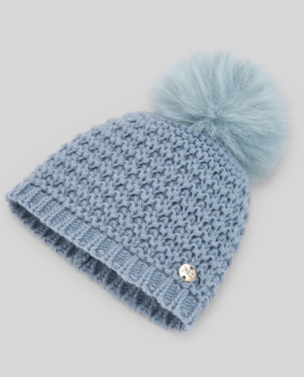 A light blue knitted hat with a blue pom pom;A blue knitted hat with a pom pom on top.