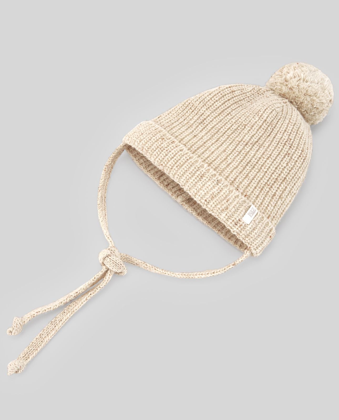 A white knitted hat with a pom pom on it