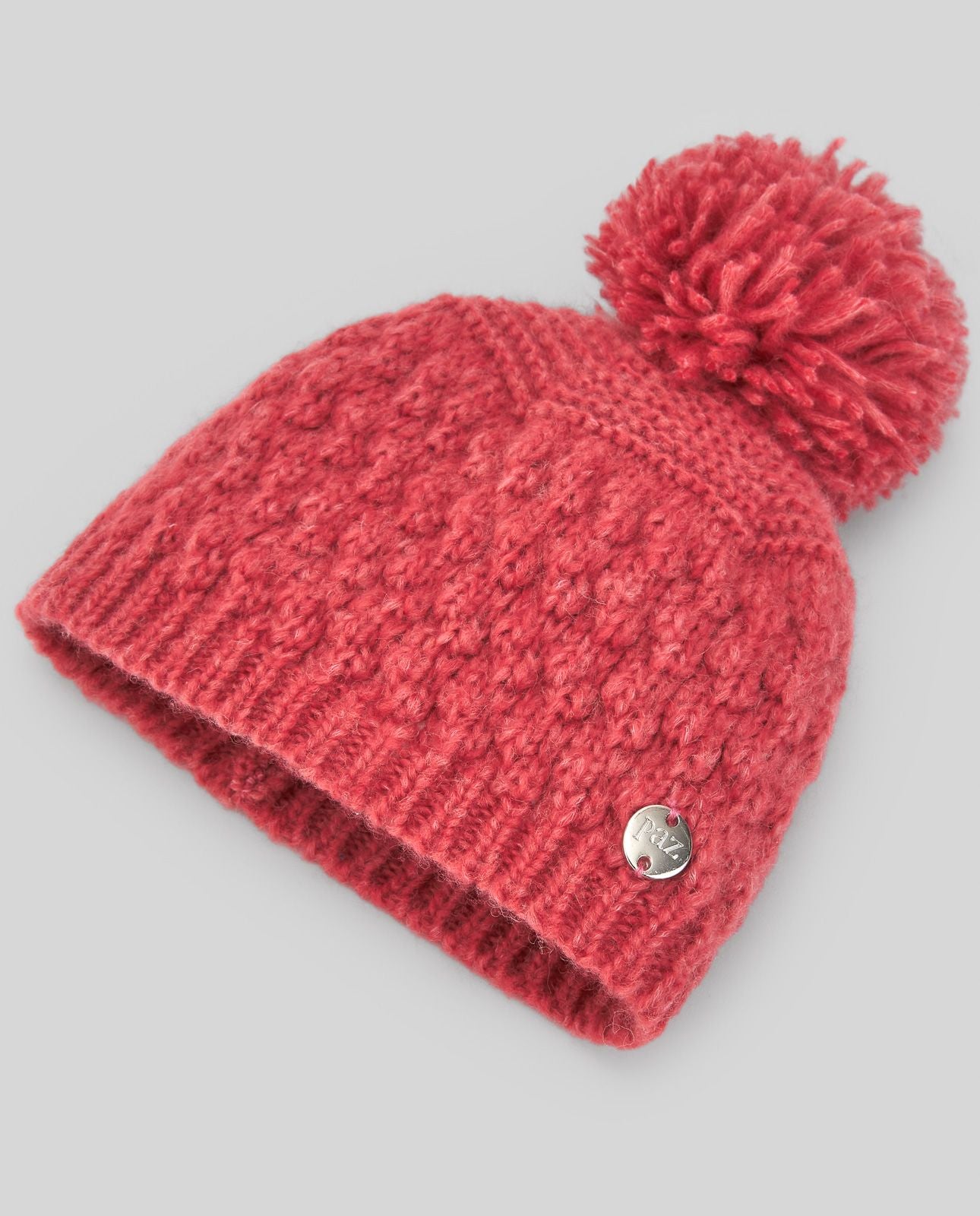 A grey knitted hat with a pom pom on top;A grey knitted hat with a pom pom on top;A red knitted hat with a large red pom pom;A red knitted hat with a pom pom on top
