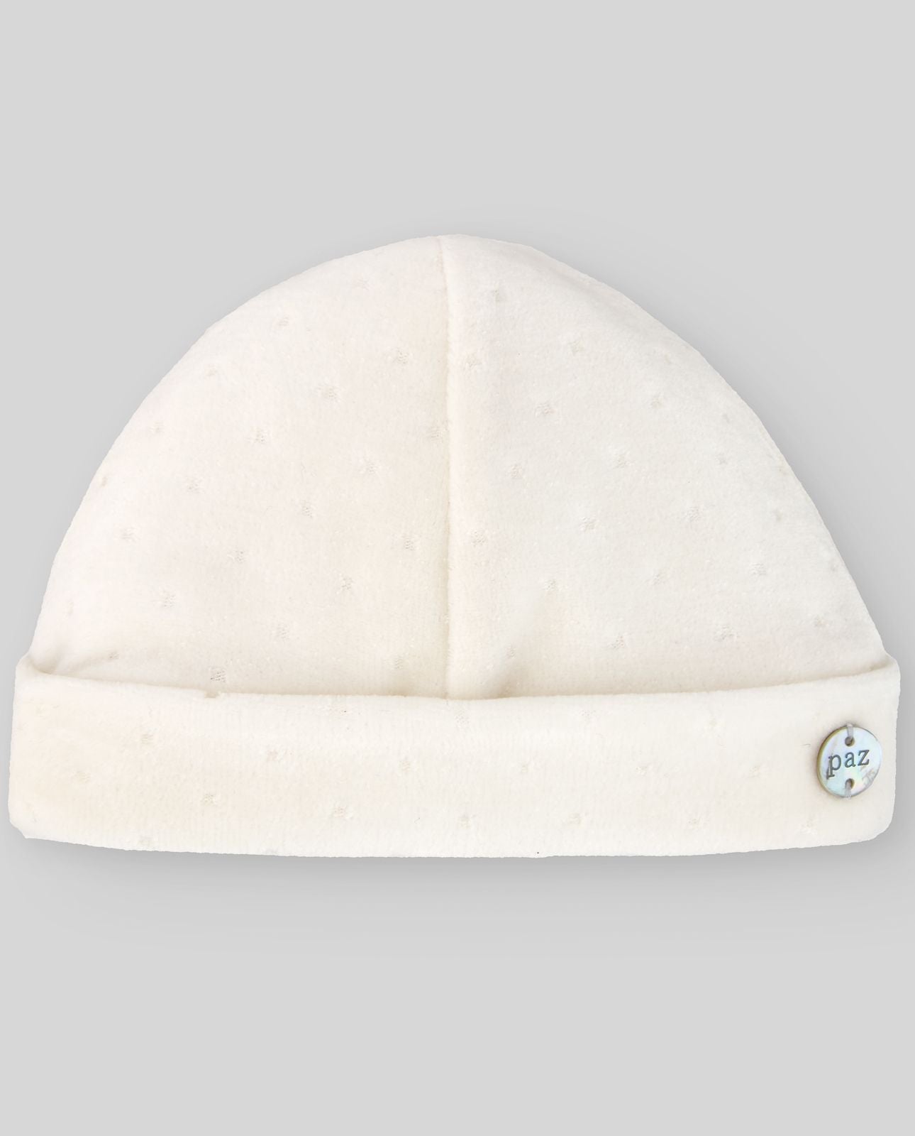 A white baby hat with a button on the side.;A white beanie with a button on the side on a white background.