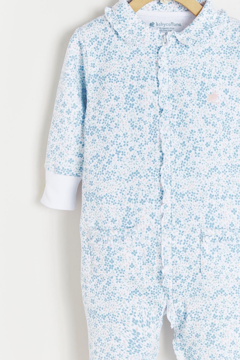 A baby onesie is hanging on a hanger on a white background.;The back of a baby onesie is hanging on a hanger.;A close up of a white shirt with blue flowers on it.;A baby onesie with blue flowers on it is hanging on a wooden hanger.