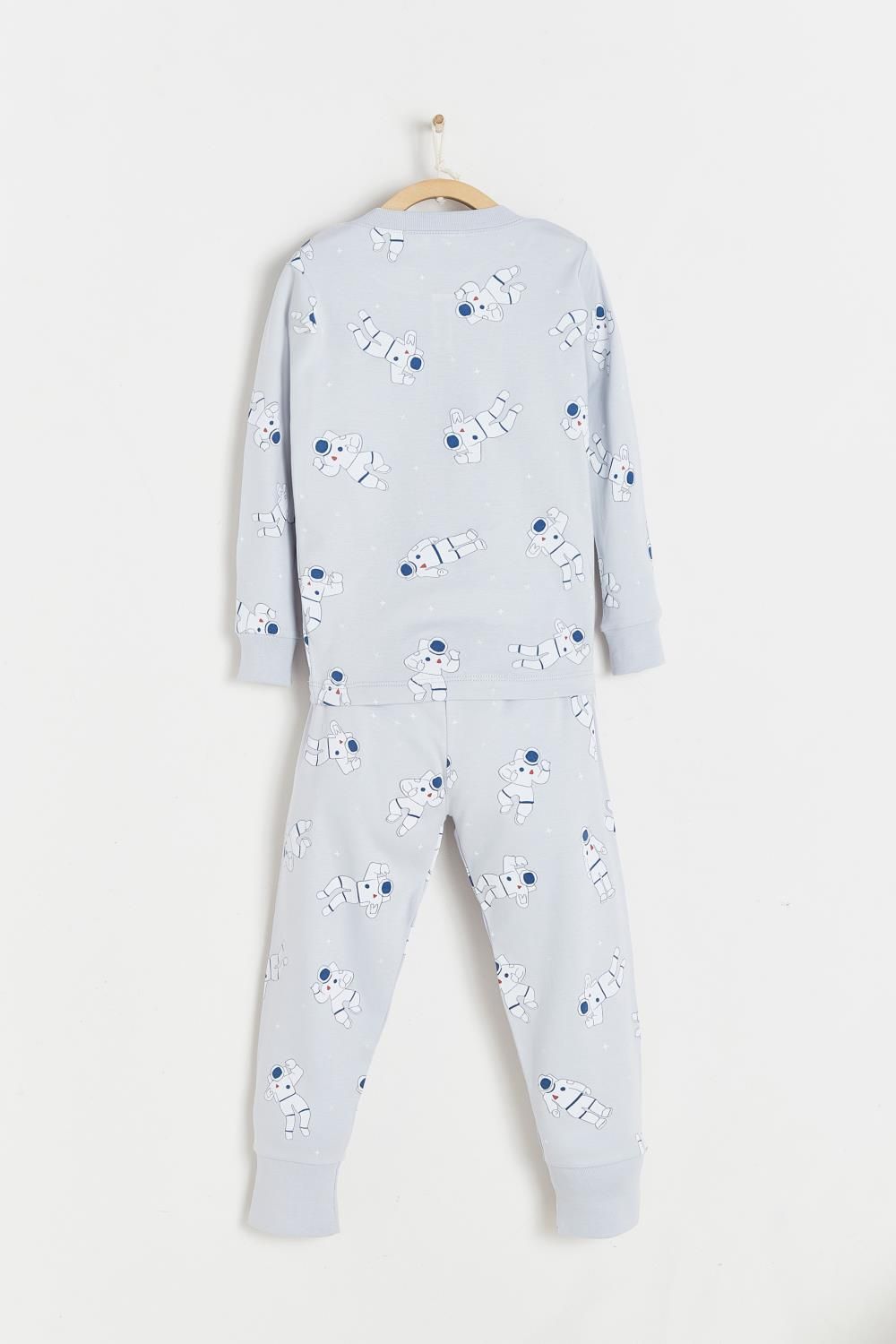 A pajama set with a pattern of sheep on it is hanging on a hanger.;The back of a pajama set with sheep on it is hanging on a hanger.;A child 's pajama set with sheep on it is hanging on a wooden hanger.