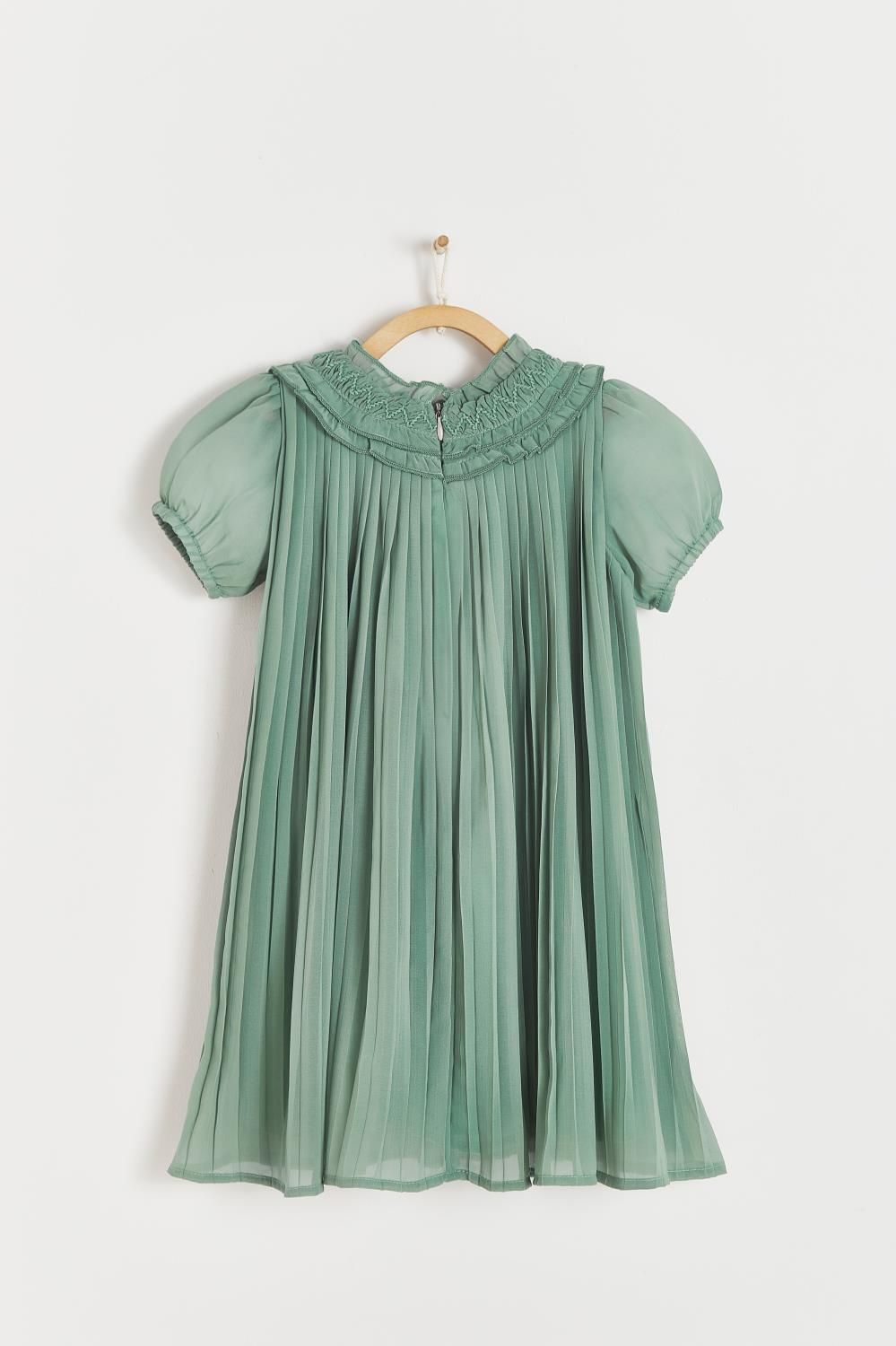 A green pleated dress is hanging on a wooden hanger.;A green dress with short sleeves is hanging on a hanger.;A close up of a green pleated skirt with ruffles on the bottom.
