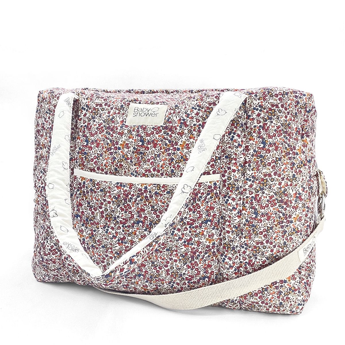 A floral diaper bag with a white strap on a white background.