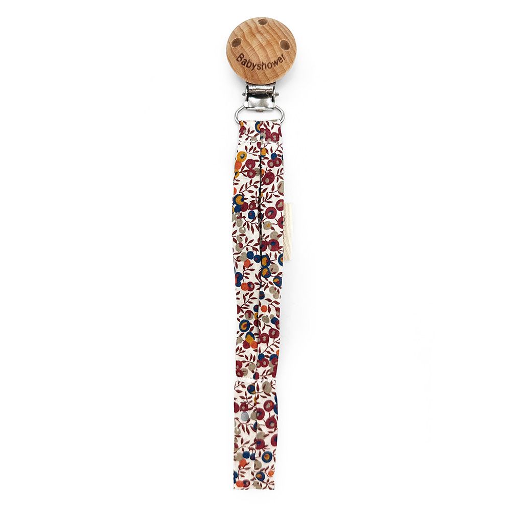 A pacifier clip with a wooden clip and a floral strap.