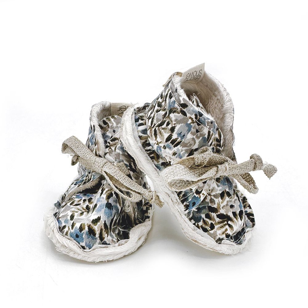 A pair of baby shoes with a leopard print on them on a white background.