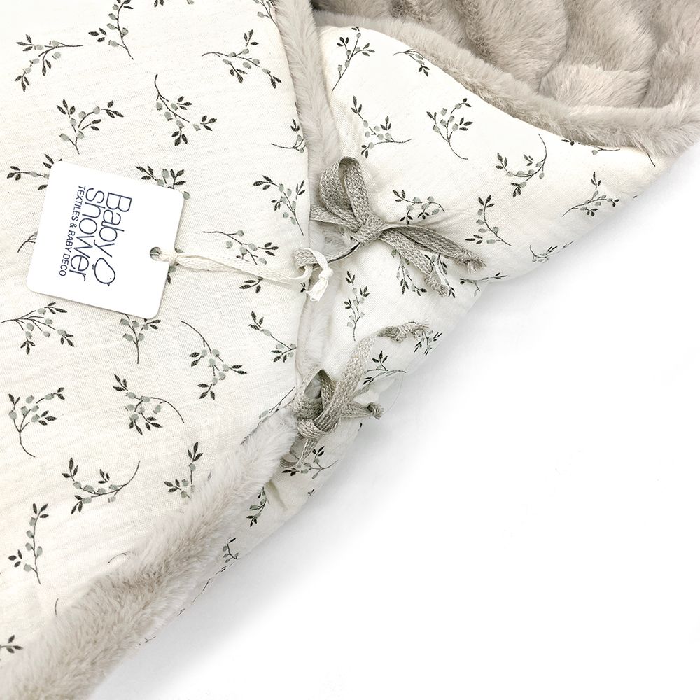 A white blanket with polka dots on it;A baby sleeping bag with a floral pattern on it;A white blanket with a hood and flowers on it;A close up of a blanket with flowers on it;A white blanket with a hood and flowers on it;A white and grey blanket with a floral pattern on it