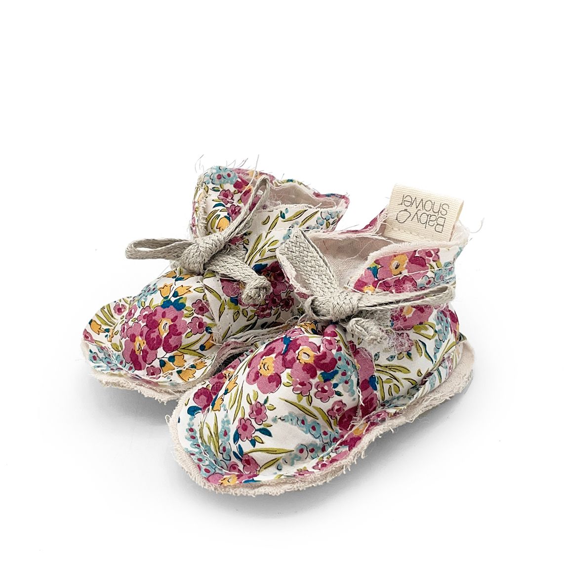 A pair of baby shoes with flowers on them on a white background.
