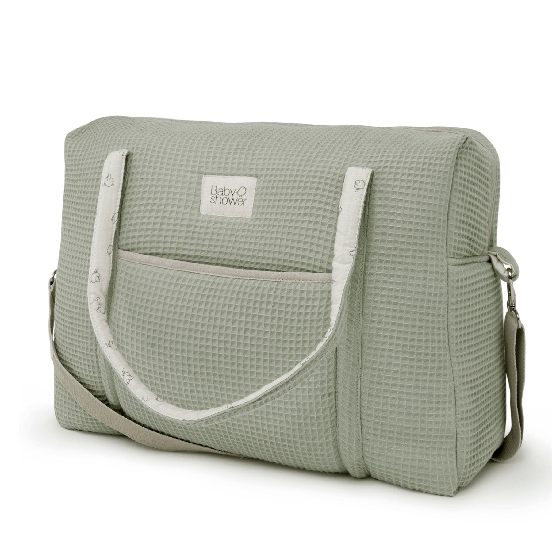 A green diaper bag with white handles and a white strap on a white background.