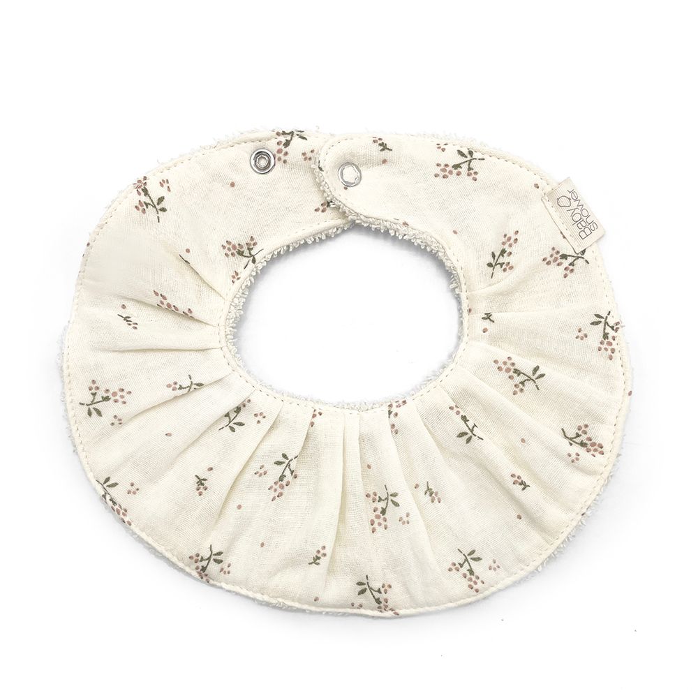 A white bib with flowers on it is on a white background.