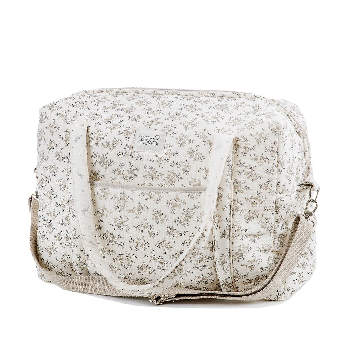 A grey diaper bag with a white strap and letters on it;A white diaper bag with a floral pattern on it;A white diaper bag with black flowers on it;A floral diaper bag with a white strap on a white background.;A green diaper bag with white handles and a white strap on a white background.;A floral diaper bag with a white strap on a white background.;A white diaper bag with a floral pattern on it
