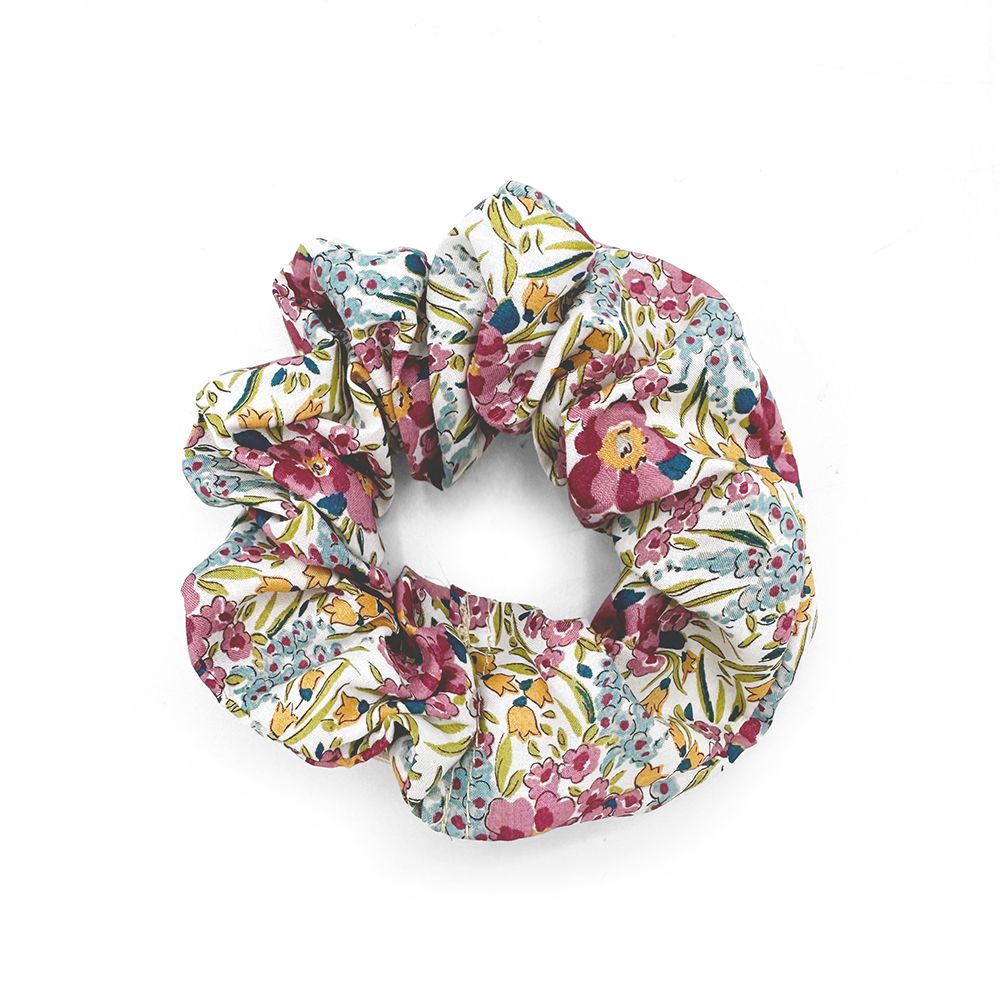 A scrunchie with a floral pattern on it is on a white background.;A scrunchie with a floral pattern on a white background.;A white scrunchie with blue and yellow flowers on it;A scrunchie with a floral pattern on a white background.