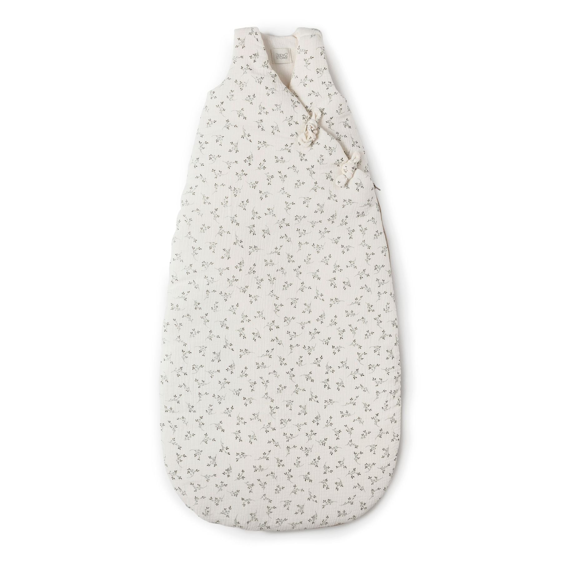 A white sleeping bag with black dots on it is on a white background.