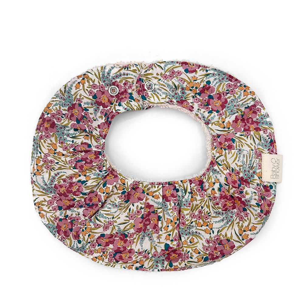 A bib with a floral pattern on it is on a white background.