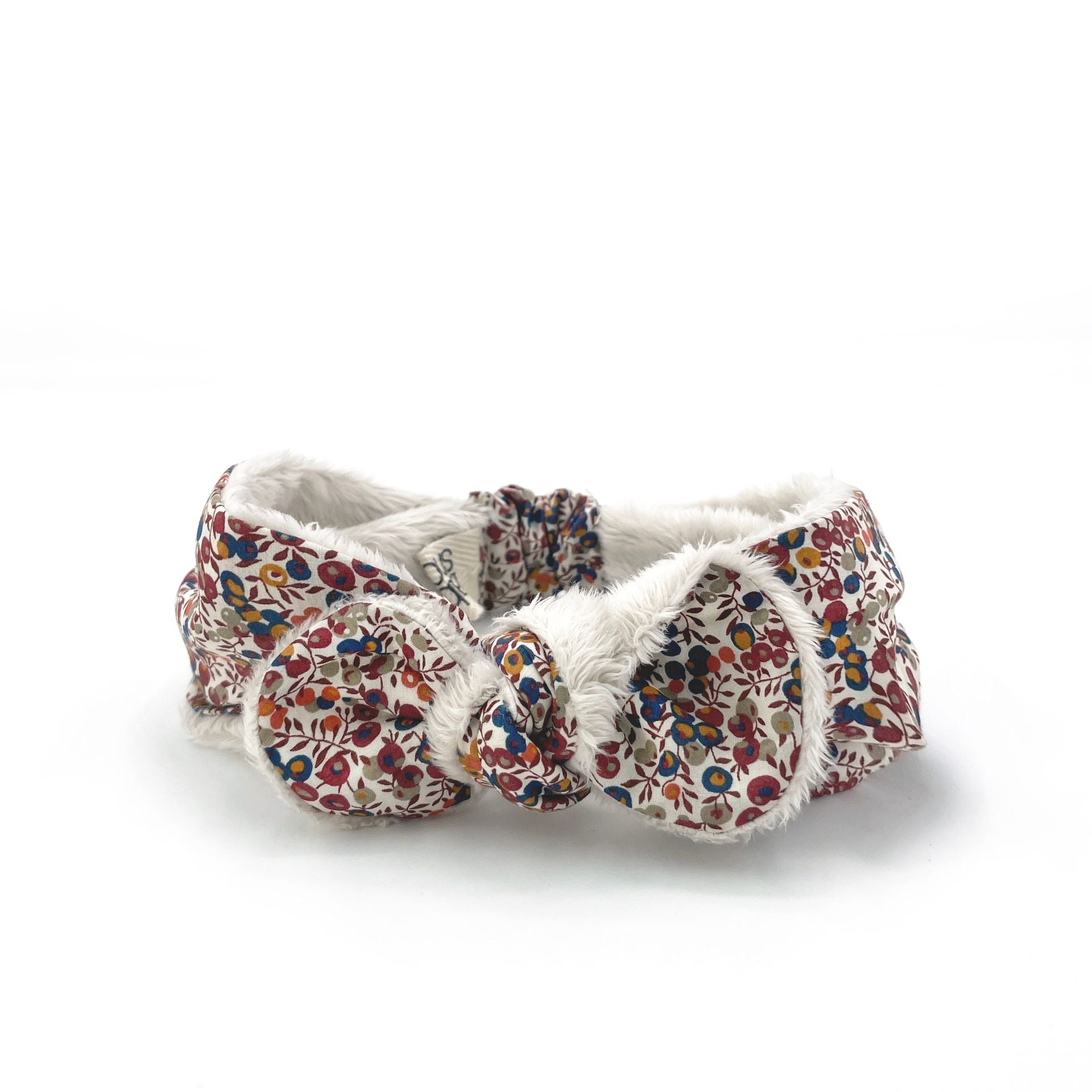 A headband with a bow on it is on a white background.