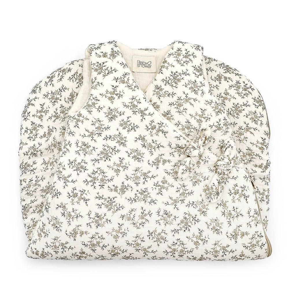 A white blanket with a floral pattern on it