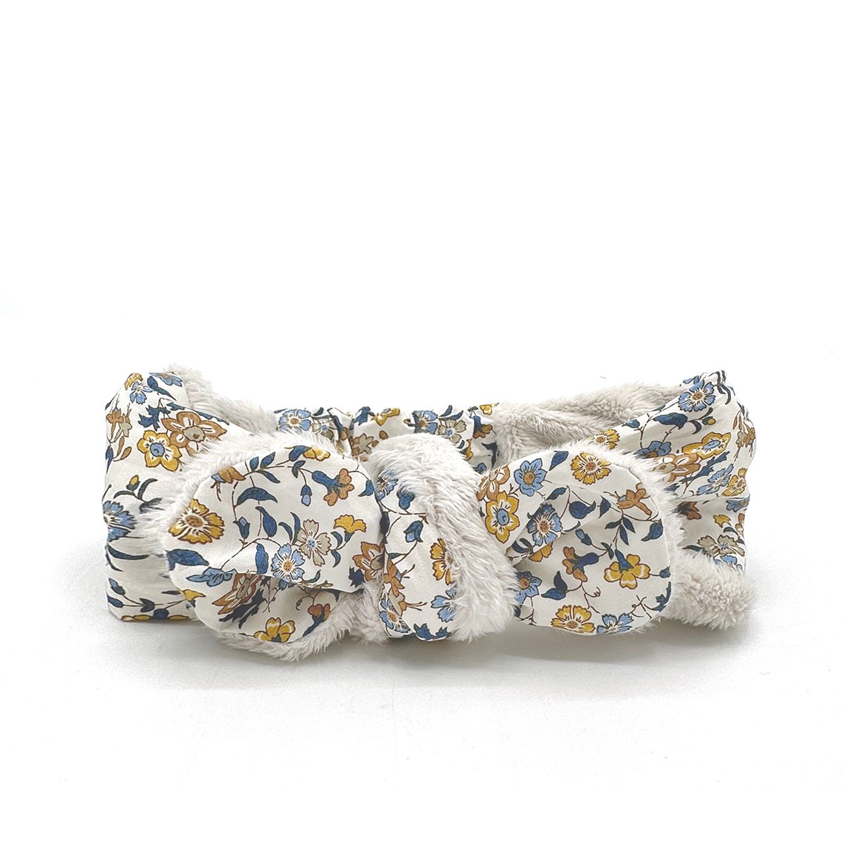A white headband with a floral pattern on it on a white background.