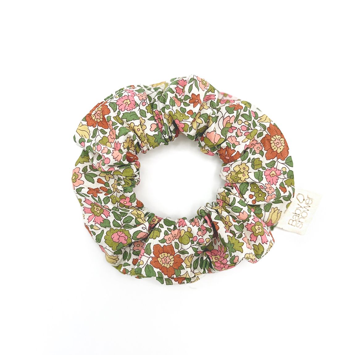 A scrunchie with a floral pattern on it is on a white background.