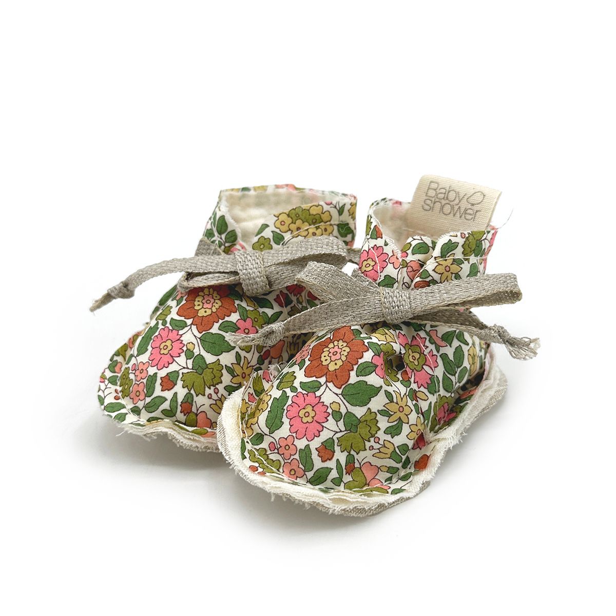 A pair of baby shoes with flowers on them on a white background.