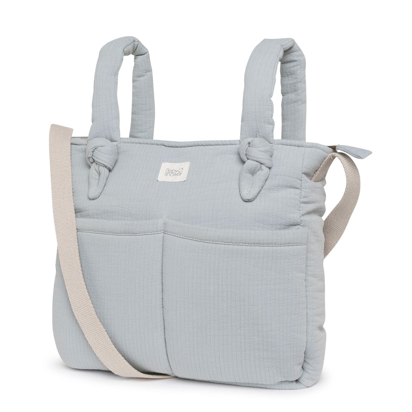 A white tote bag with a floral pattern on it;A light blue diaper bag with a beige strap;A white tote bag with a floral pattern on it;A white tote bag with flowers on it and a white strap