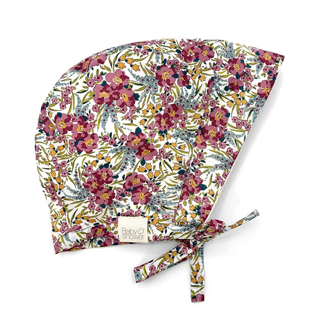 A baby hat with a floral pattern on it is on a white background.