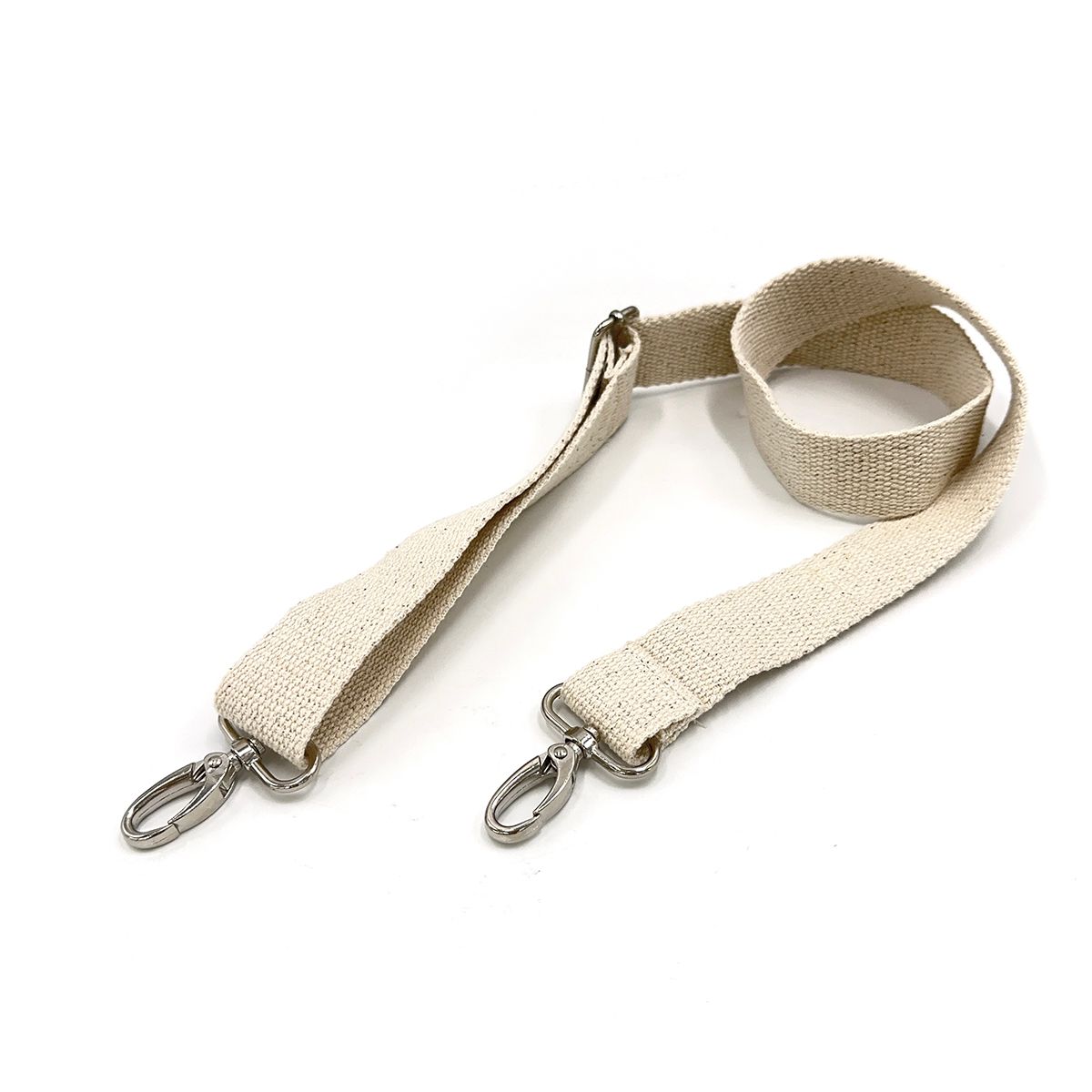 A close up of a lanyard with a metal hook on a white surface.;A beige strap with silver hooks on a white background