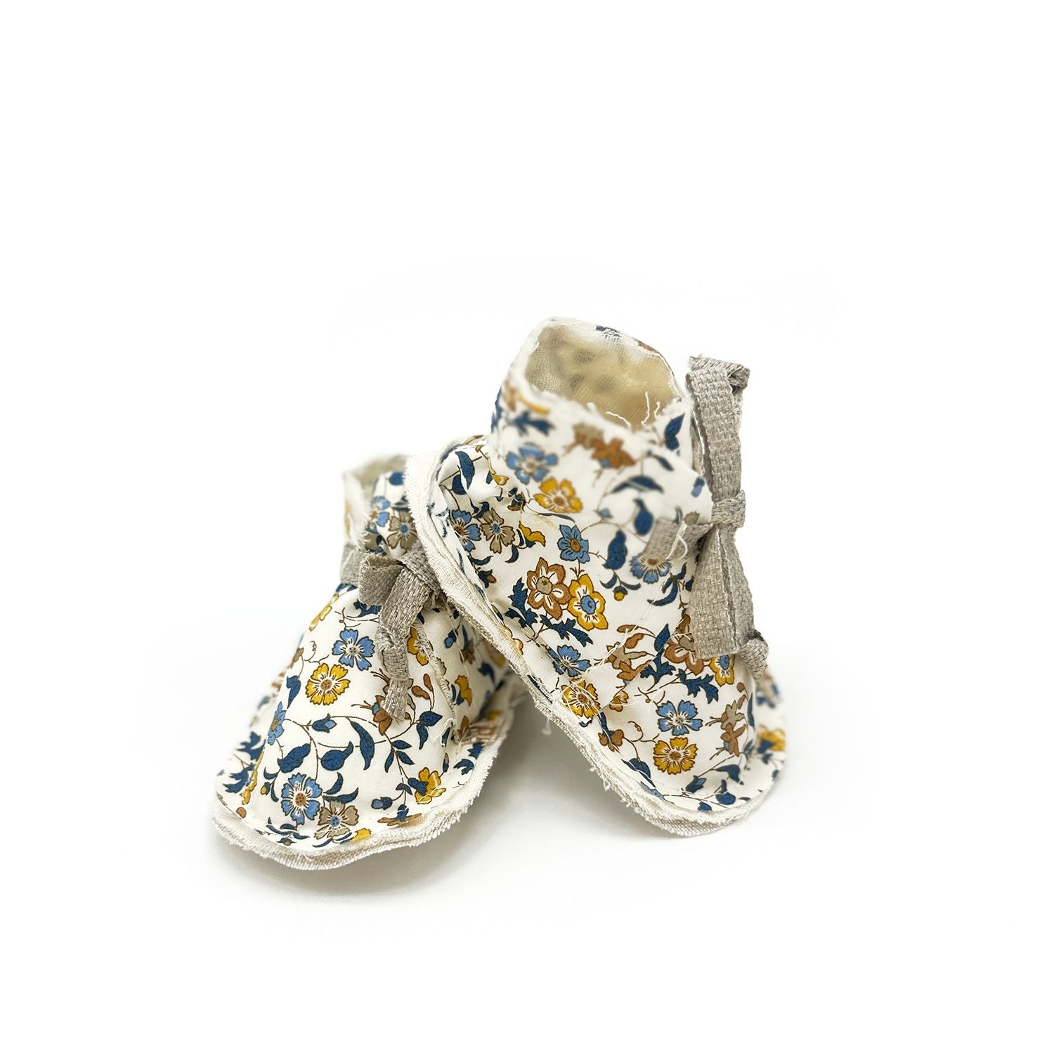 A pair of baby shoes with a floral pattern on a white background.