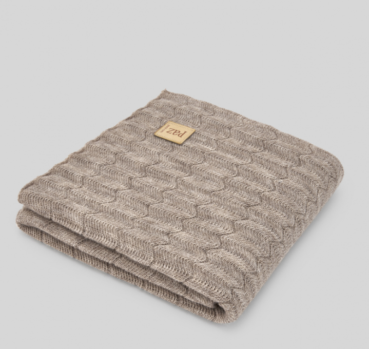 A brown knitted blanket with a brown label on it