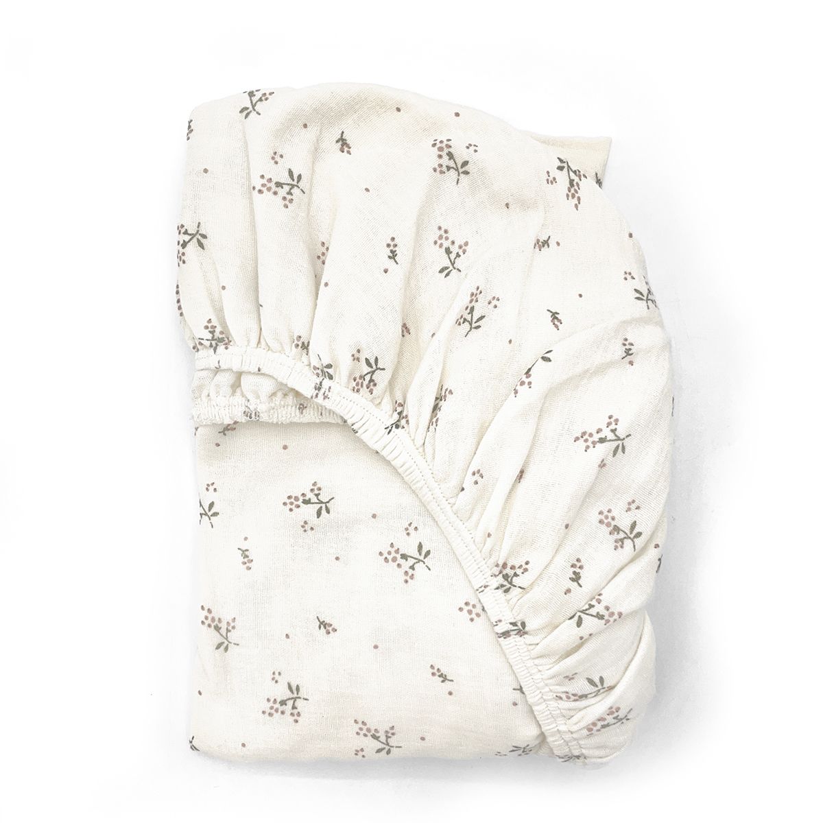 A white sheet with black flowers on it is rolled up on a white surface.