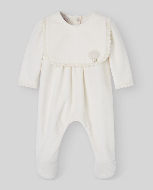 A baby is wearing a white onesie with a lace collar;A baby in a white outfit is laying on a blue blanket.