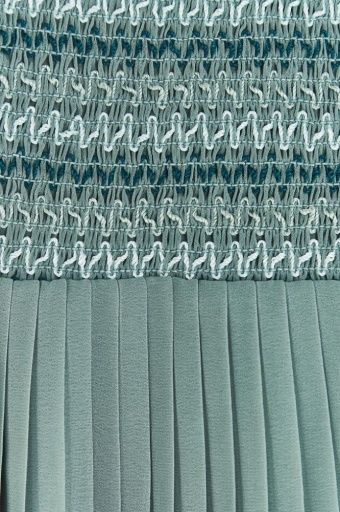A green pleated dress is hanging on a wooden hanger.;A green dress with short sleeves is hanging on a hanger.;A close up of a green pleated skirt with ruffles on the bottom.