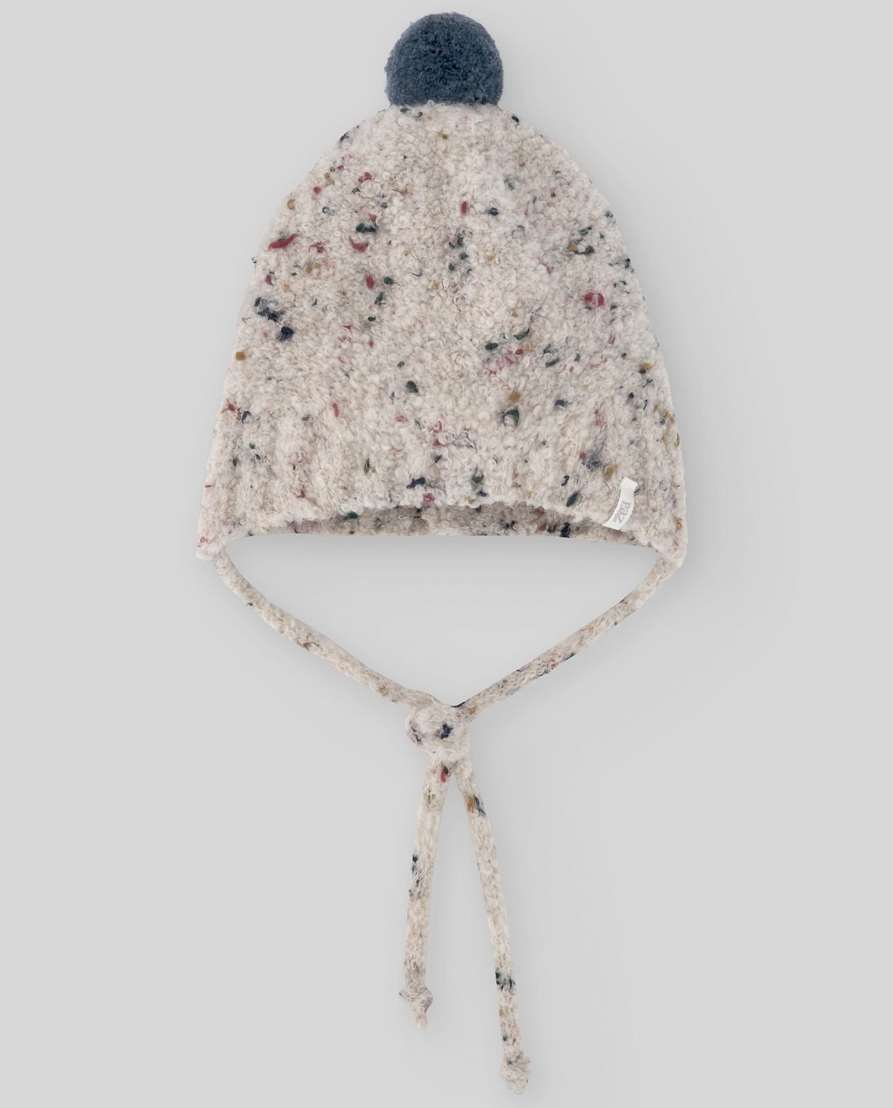 A white knitted hat with a blue pom pom on a white background.;A white hat with a blue pom pom on top
