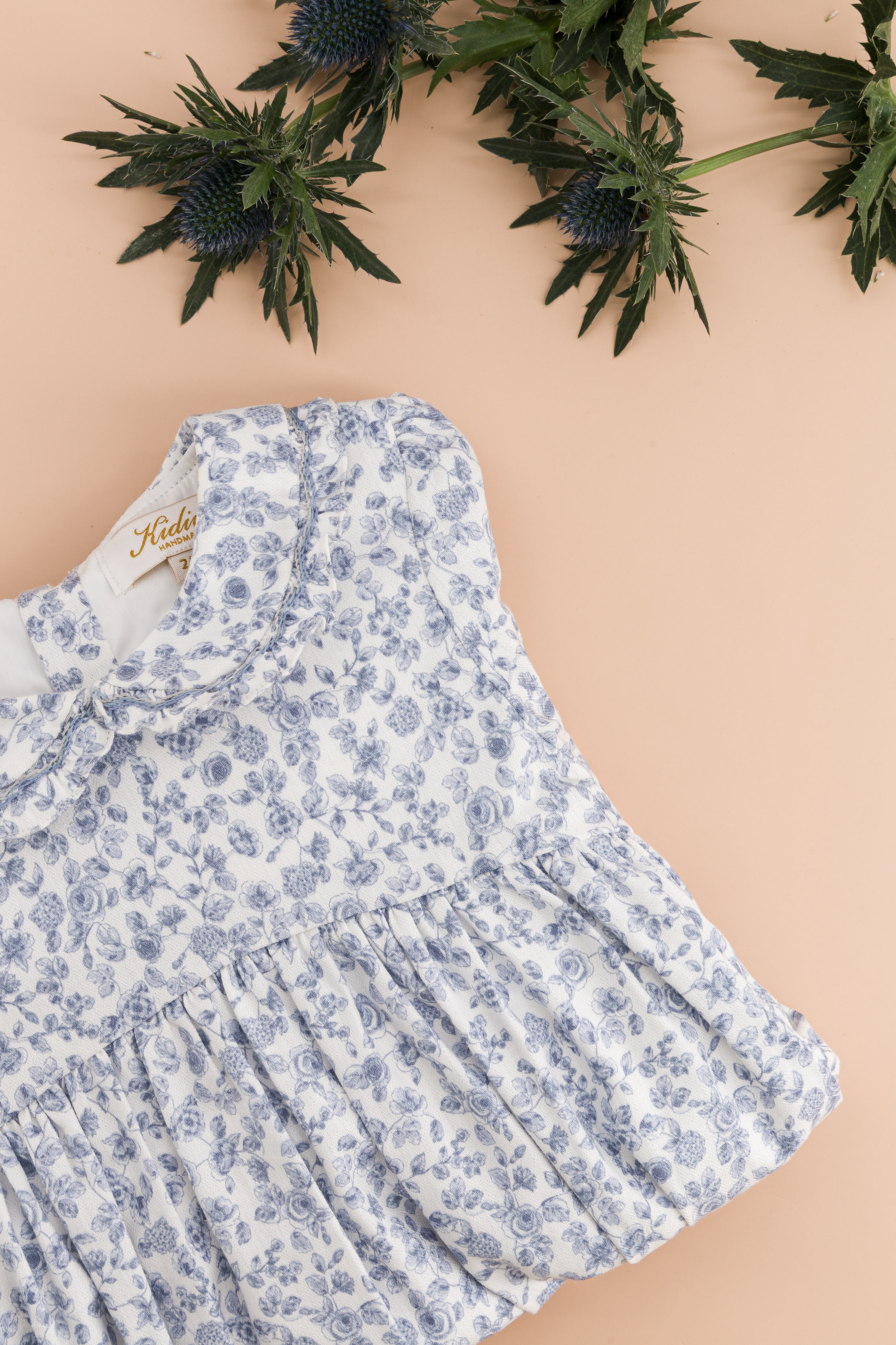 Anthea, smocked girl romper, in Blue garden print