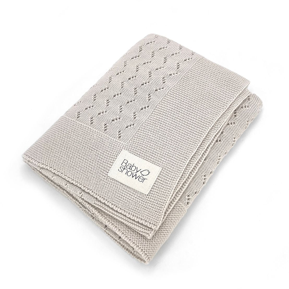 A close up of a knitted blanket on a white background.