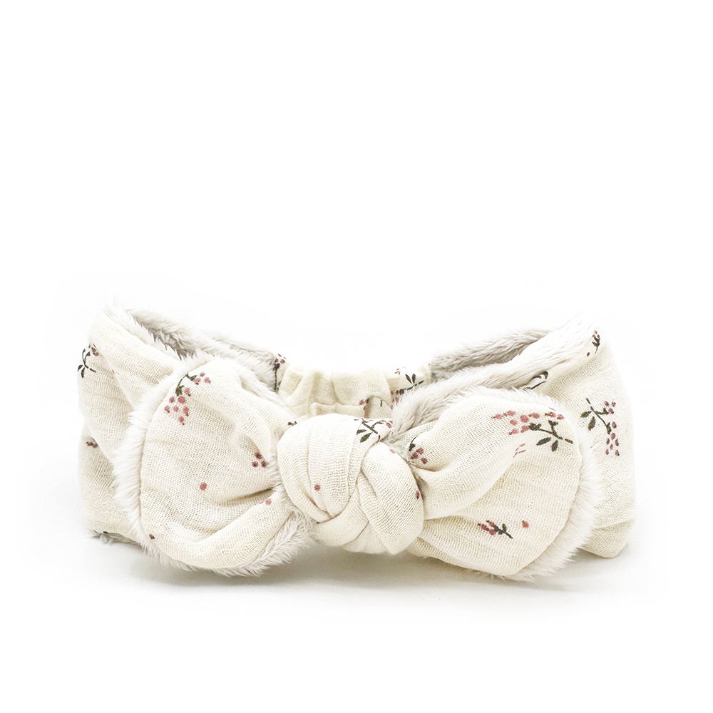 A white headband with a bow on it on a white background.