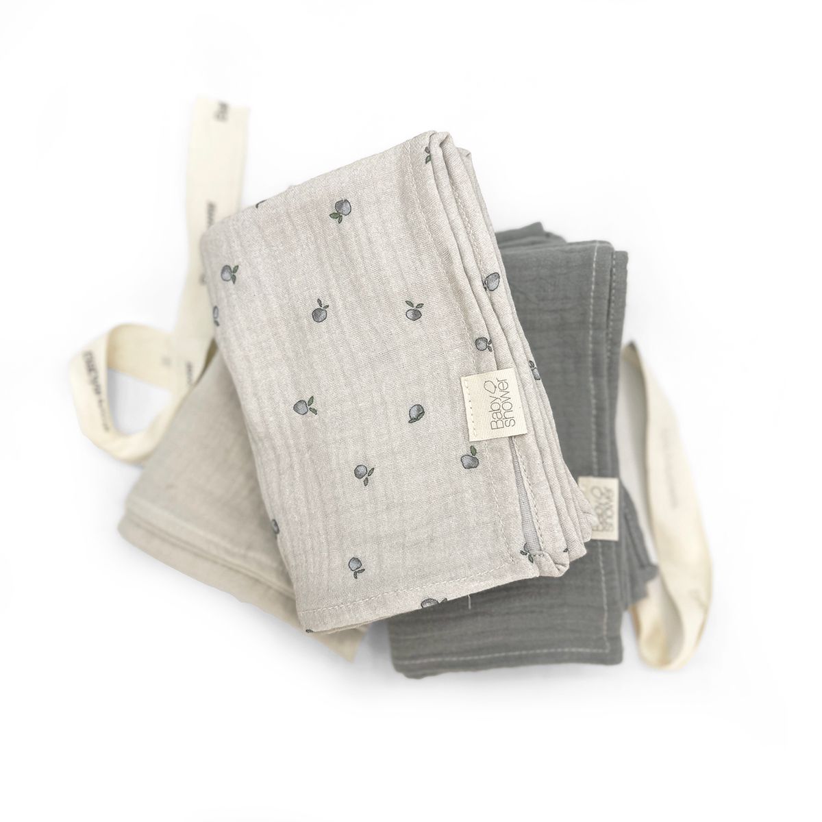 A stack of towels tied together with a ribbon on a white background.;A bunch of towels and socks are tied together with a bow.;Three blankets are stacked on top of each other on a white background.;Three towels are stacked on top of each other on a white background.;Three towels are stacked on top of each other on a white surface.