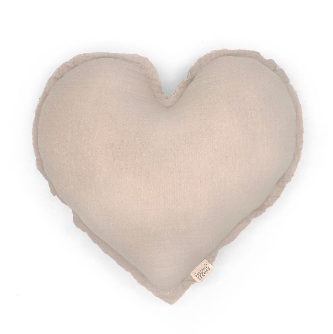 A heart shaped pillow is sitting on a white surface.