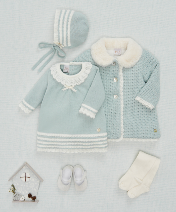 A baby girl is wearing a blue coat with a white fur collar.;A baby girl is wearing a light blue coat with a white collar.;A baby 's clothes are laid out on a white surface