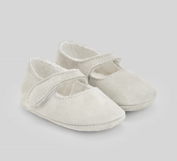 A pair of white baby shoes on a white background.