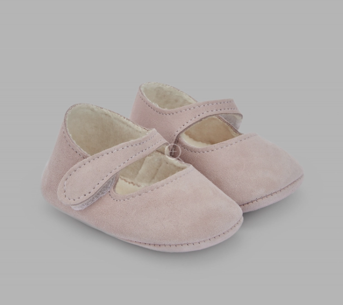 A pair of pink baby shoes on a grey background