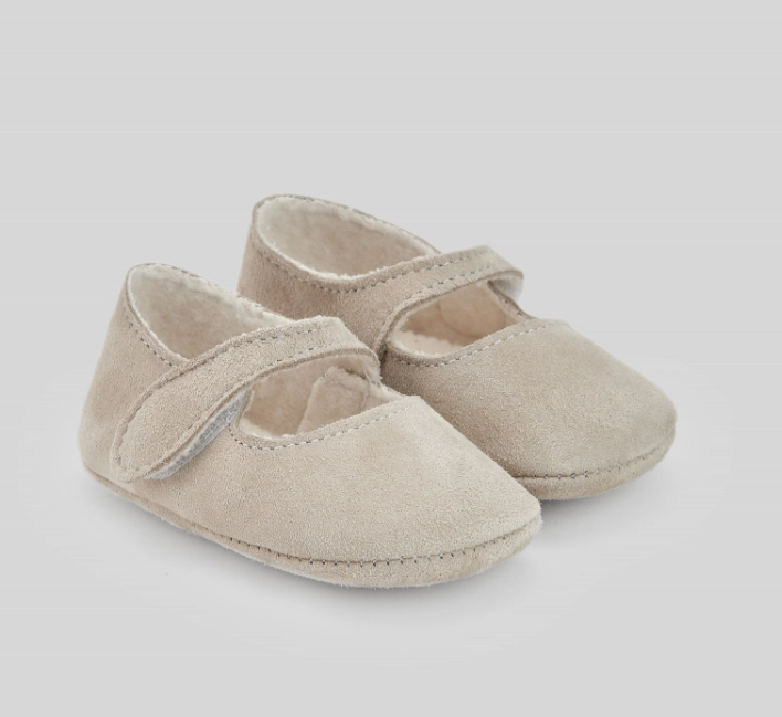 A pair of beige baby shoes on a white background